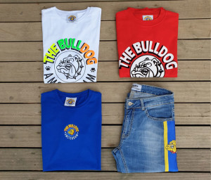 4 capi di abbigliamento da uomo del brand The Bulldog appoggiati a terra su pavimento di legno dell'Outlet Unionmoda